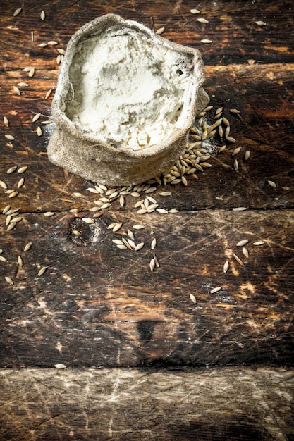 Foto sacco di farina di grano su uno sfondo di legno