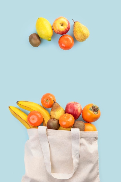 Bag of fresh fruits on blue background with space for text