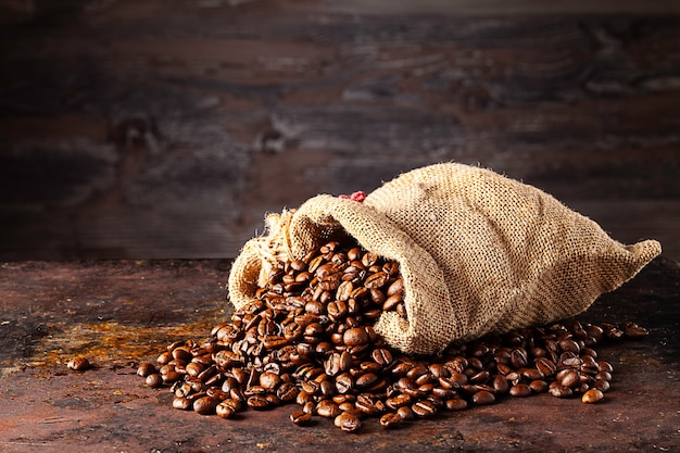 Bag with fresh roasted coffee lying in front of wooden wall