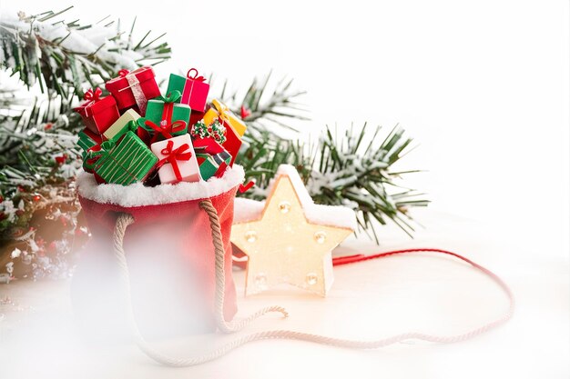 Сумка с подарками и рождественскими украшениями шары рядом с звездным светом елки ветви на снегу