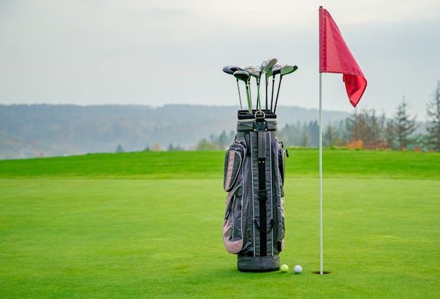 Bag with golf equipment on green pitch