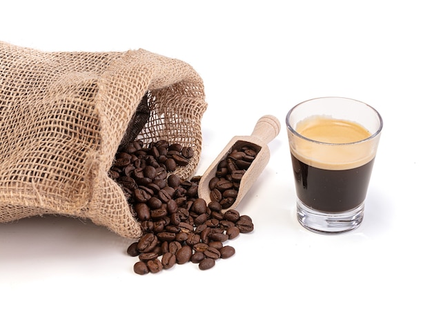 Bag with roasted coffee with an espresso coffee cup on white