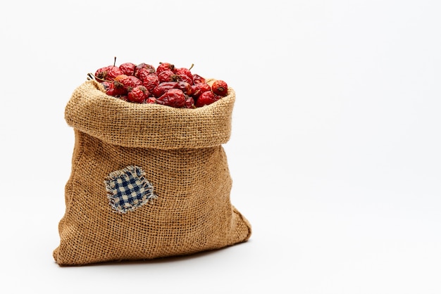Bag with rose hips on white