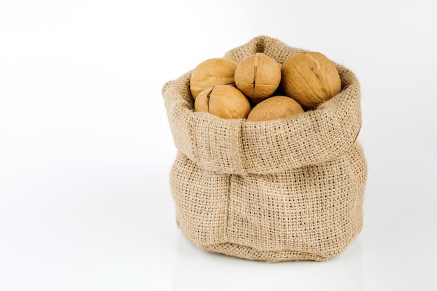 Bag with walnuts isolated on white background