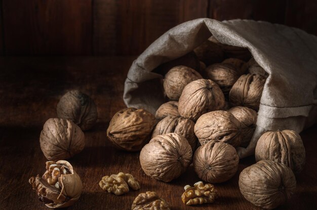 bag with walnuts and kernels on a dark wooden background