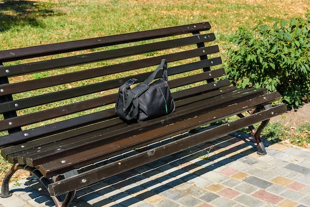 Bag on a wooden bench in city park