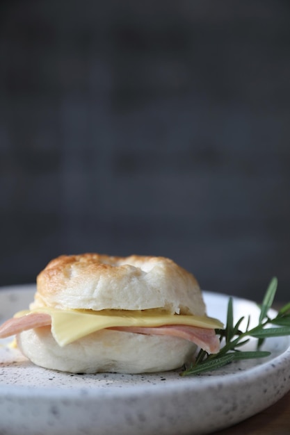 Bagel ham cheese in close up on wood background in coffee shop