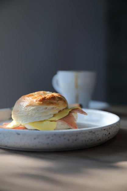 Bagel ham cheese in close up on wood background in coffee shop