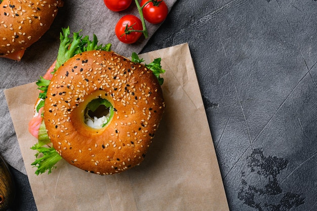 Bagel met rode vis en zachte kaas op grijze stenen tafel achtergrond bovenaanzicht plat lag met kopieerruimte voor tekst