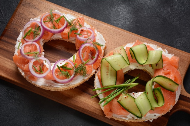 Bagel sandwich with salmon, cream cheese, cucumber, and onions