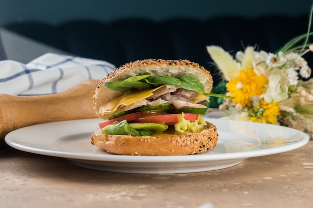 Bagel with chicken, cheese and vegetables.