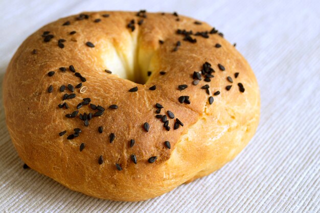 A bagel with cumin on a light linen napkin.