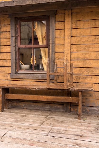 Bagels hanging in the window of a village house. Bench in front of the house.