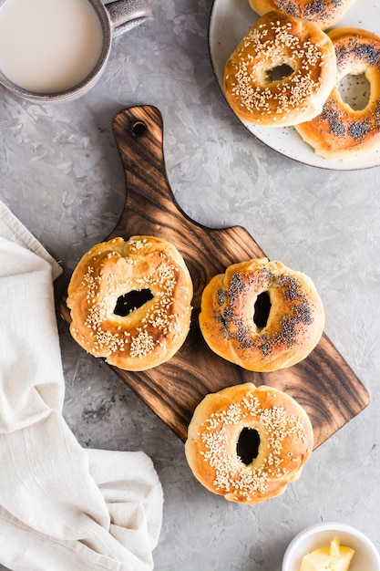 Bagels met maanzaad en sesamzaadjes op een bord en een kopje koffie Bovenaanzicht en verticale weergave