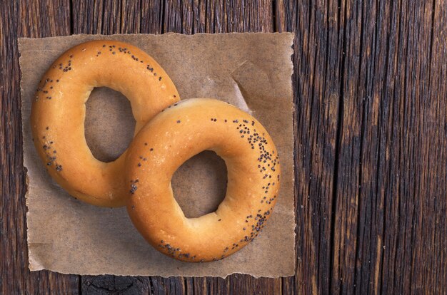 Bagels met maanzaad op donkere houten tafel, bovenaanzicht