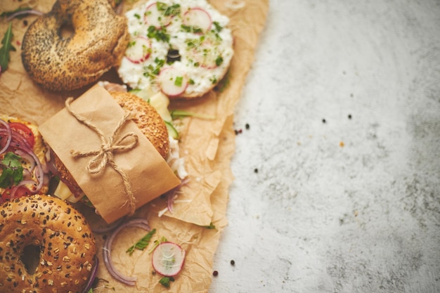 사진 이탈리아 햄과 크림 치즈, 후무스, 라면, 러드, 갈색 베이킹 페이퍼에 감싸서 가져갈 수 있는 건강한 아침식사 개념