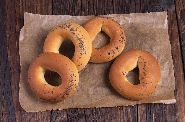 Bagels with poppy seeds on dark wooden table