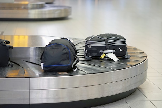 Baggage on conveyor belt at the airport. Baggage claim area in the airport, abstract luggage line with many suitcases.