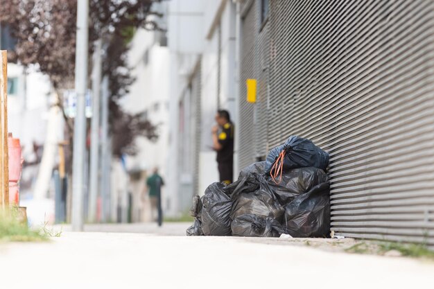 Bags and trash beside a street wall garbage on the street