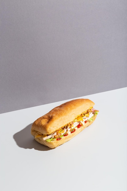 Baguette sandwich with chicken salad on grey hard shadow high quality photo