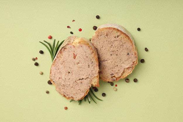 Baguette slices with pate on green background