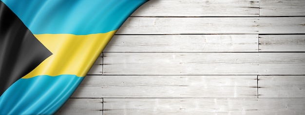 Bahamas flag on old white wall. Horizontal panoramic banner.