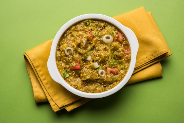 Photo baigan bharta in hindi or vangyache bharit in marathi is a roasted and mashed eggplant fry or curry, favourite maharashtrian menu, served in a bowl or karhai or pan. selective focus