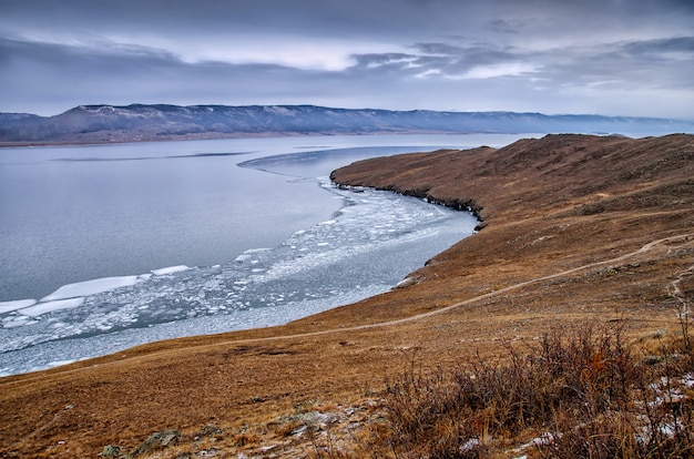 Baikal lake en rock in de koude december. tijd van bevriezing. ijsschotsen zwemmen op het water