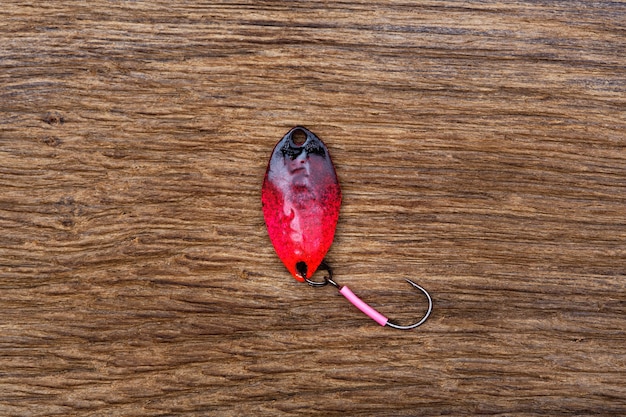 Bait with the hook for fishing on the old wooden table. High resolution photo.