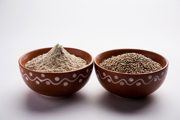 Bajra, pearl millet or sorghum grains with it's flour or powder in a bowl, selective focus