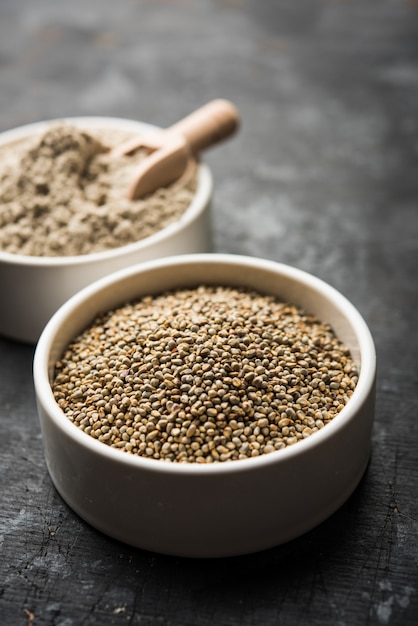 Bajra, pearl millet or sorghum grains with it's flour or powder in a bowl, selective focus