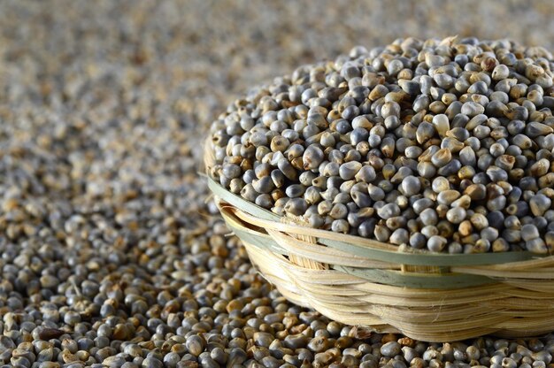 Photo bajra pearl millet in wooden bamboo basket