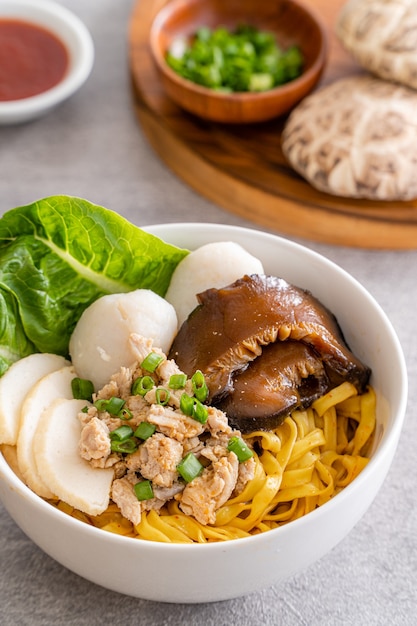 Bak chor mee le tagliatelle vengono saltate nell'aceto carne macinata fettine di maiale fegato di maiale in umido funghi affettati polpette di carne e pezzetti di lardo fritto