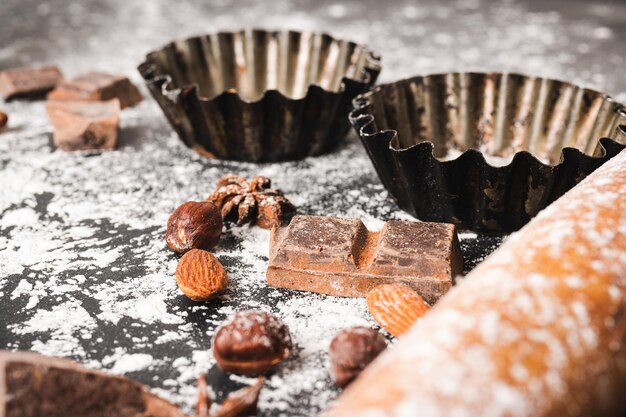 Foto bakconcept cupcake vorm en voedselingrediënten op een donkere achtergrond bereiden zich voor op het koken