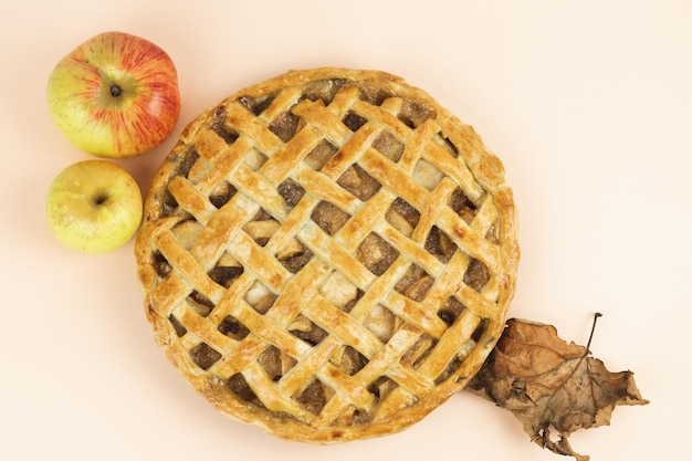 Baked apple pie with trellis decoration Apples and dried leaves Copy space