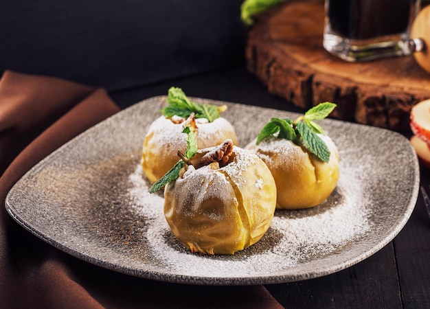 Baked apples stuffed with walnuts on plate