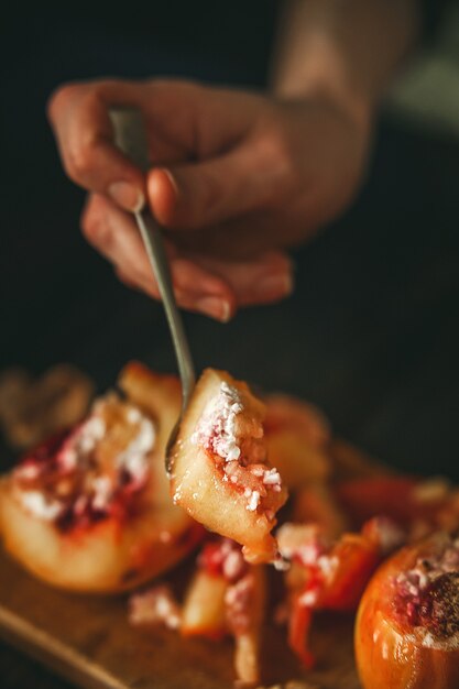 Baked apples with cottage cheese with berries and nuts, topped with honey and sprinkled with cinnamon. on a wooden surface in a rustic style