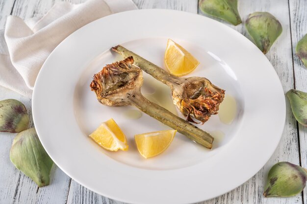 Baked artichoke with lemon on the plate