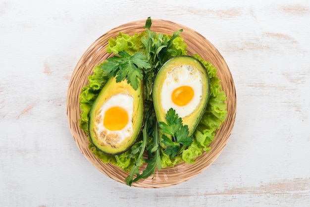 Baked avocado with egg Healthy food On a wooden background Top view Copy space