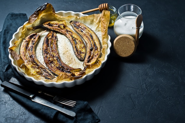 Baked bananas with honey in a baking dish. 