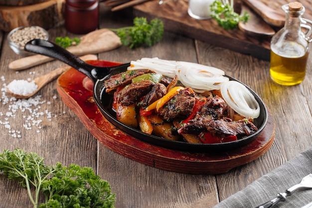 Baked beef with vegetables in cast iron pan