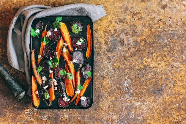 Baked beets and carrots in a vintage black pan, with ricotta fennel seeds and fresh coriander