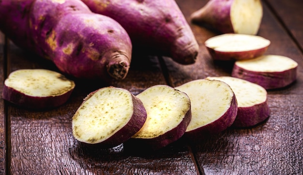 Baked or boiled sweet potato sliced on wooden table vegan food served hot rustic cuisine organic vegetables