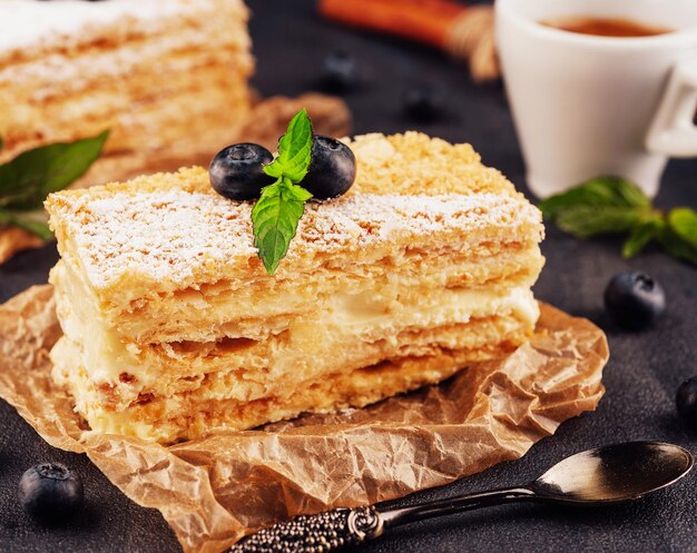 Baked cake Napoleon Millefeuille garnished with blueberry and mint