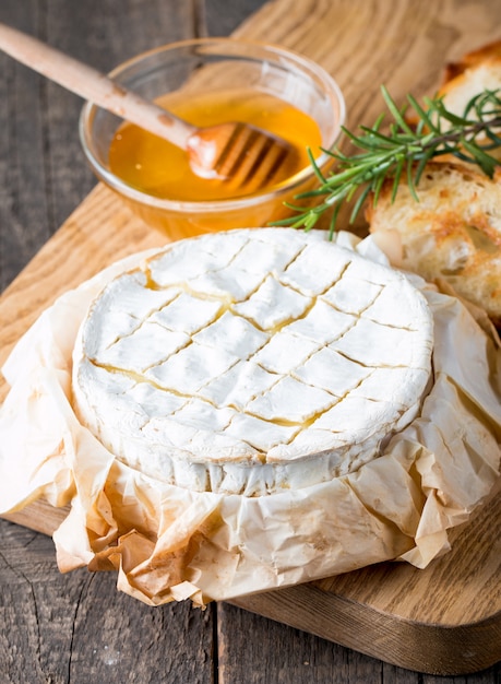 Baked camembert or Brie cheese on a wooden board.