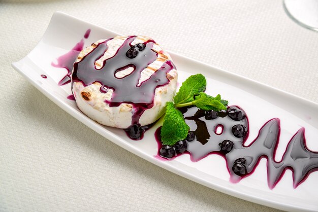 Baked Camembert cheese with cranberry sauce and mint