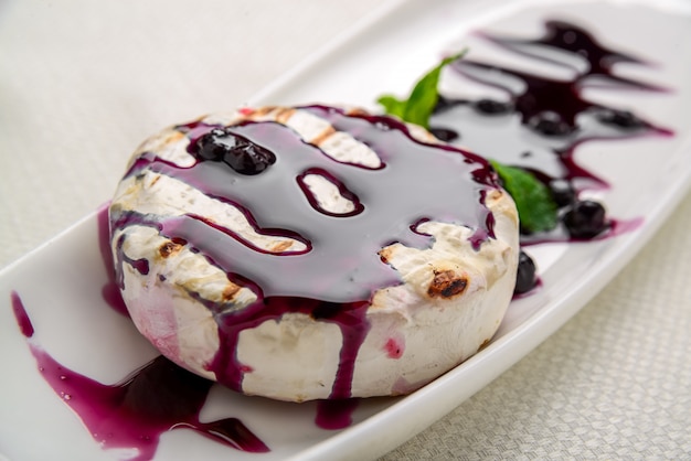 Baked Camembert cheese with cranberry sauce and mint