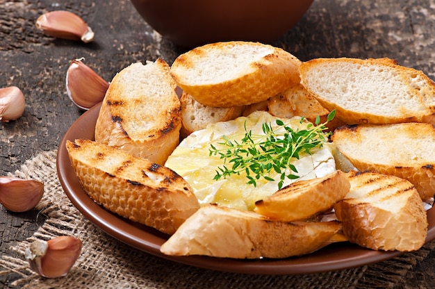 Запеченный сыр Камамбер с тимьяном и тостами, натертый чесноком
