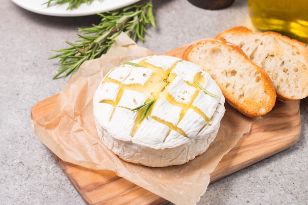 Camembert al forno a pasta molle. brie alla griglia con toast e rosmarino.