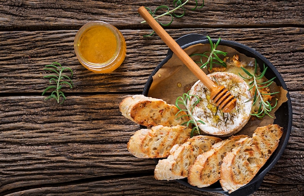 Baked cheese Camembert with rosemary and honey. Tasty food. Top view. Flat lay